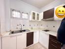 Clean modern kitchen with tiled backsplash and white cabinetry