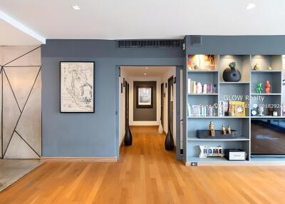 Spacious living area with wooden flooring and built-in shelving