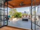 Spacious outdoor patio with a city view, wooden ceiling with fan, and seating area