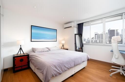 Spacious bedroom with large windows and modern furnishings