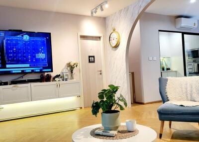 Modern living room with wall-mounted TV, archway, and contemporary decor
