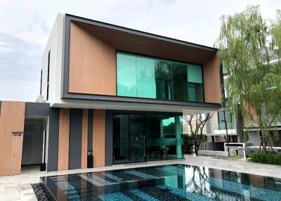 Modern two-story house with a large glass facade and a pool