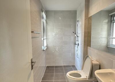 Modern bathroom with toilet, sink, and shower