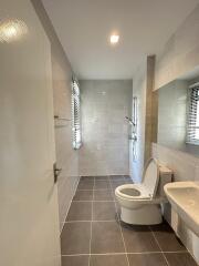 Modern bathroom with toilet, sink, and shower