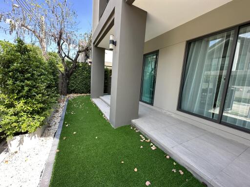 Well-maintained patio with artificial grass and shrubs