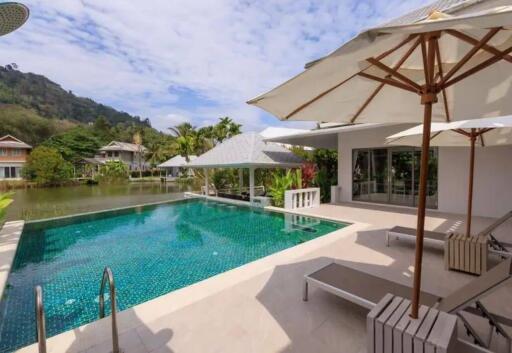 Outdoor area with pool, loungers, and umbrellas