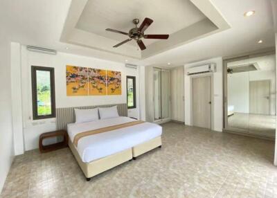 Spacious bedroom with modern decor and ceiling fan