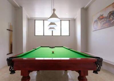 A game room with a pool table and modern lighting