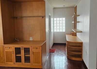 Spacious living area with wooden furniture and built-in shelving