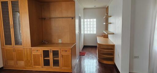 Spacious living area with wooden furniture and built-in shelving