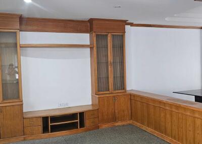 Living room with wooden built-in shelves and cabinets