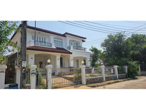 Exterior view of a two-story house with a fenced yard