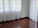 Living room with hardwood floors and sheer curtains