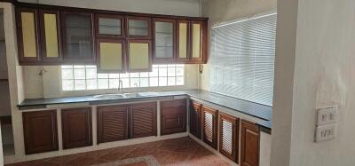 Modern kitchen with wooden cabinets and large window