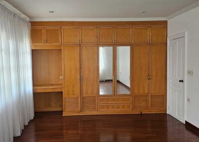Spacious bedroom with built-in wooden wardrobe and desk