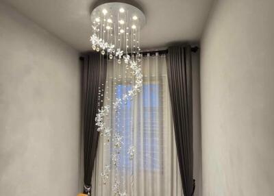 Hallway with elegant chandelier and window curtains