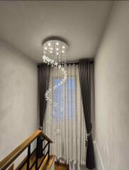 Hallway with elegant chandelier and window curtains