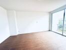 Empty room with large window and wooden floor