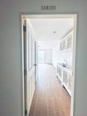 View of a minimalist kitchen with white cabinetry and tiled flooring