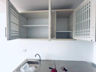 Kitchen with open cabinets, sink, and counter space