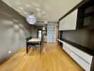 Modern dining area with adjacent kitchen featuring wooden flooring, contemporary furniture, and patterned accent wall