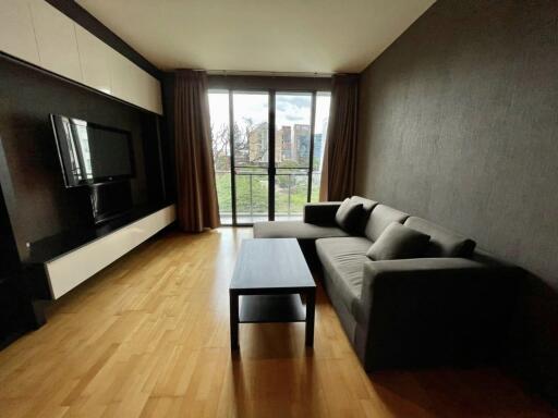 Spacious living room with a large window and a modern sofa