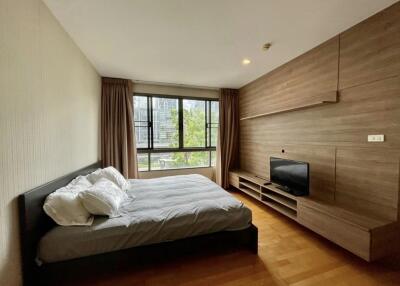 Spacious bedroom with large window and modern furnishings