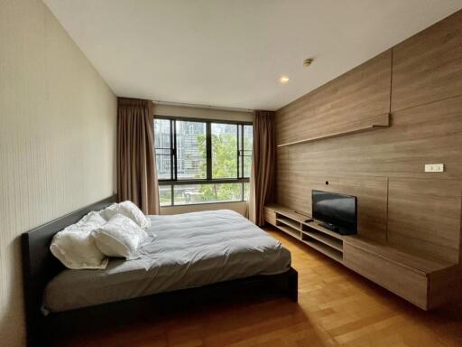 Spacious bedroom with large window and modern furnishings