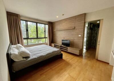 Modern bedroom with large window and wooden flooring