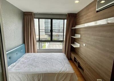 Modern bedroom with large window, bed, and built-in wooden furniture