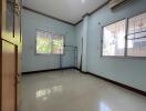 Empty bedroom with windows and tiled floor