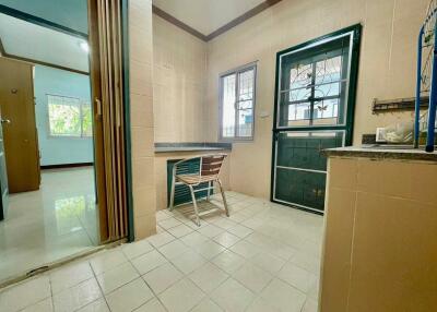 Simple kitchen with wooden chair and tiled floor