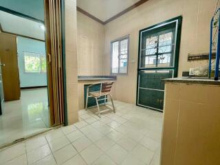 Simple kitchen with wooden chair and tiled floor