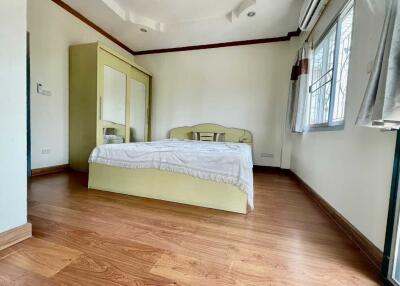Bedroom with wooden flooring and large windows