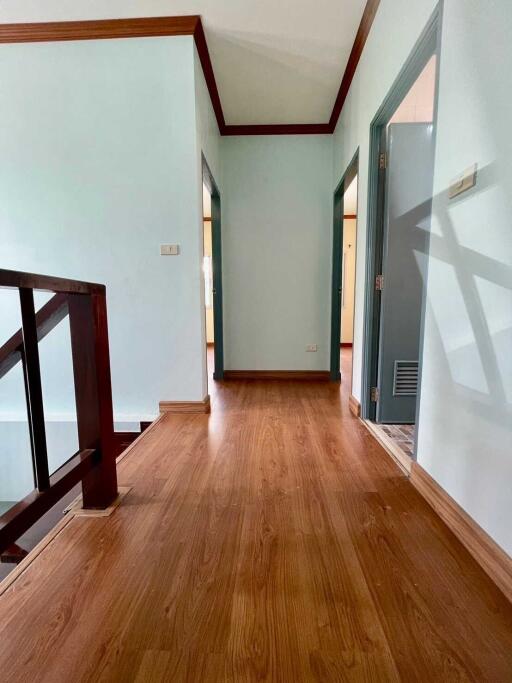 Hallway view with wooden floors and access to various rooms