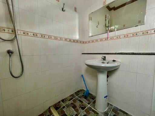 Bathroom with pedestal sink and wall-mounted mirror