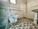 Clean bathroom with tiled floors and walls, featuring a toilet, sink, and shower.