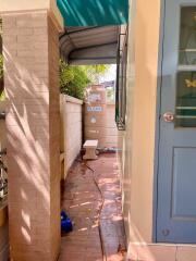 Outdoor area next to a water tank and a blue door