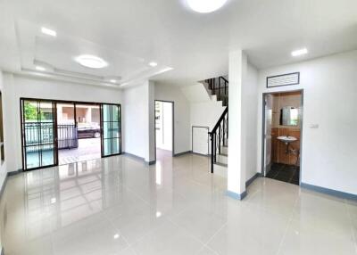 Spacious living area with large windows and staircase