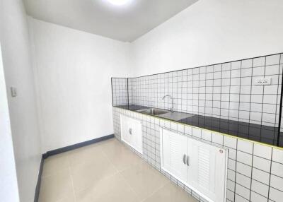 Modern minimalist kitchen with tiled backsplash and dual sinks