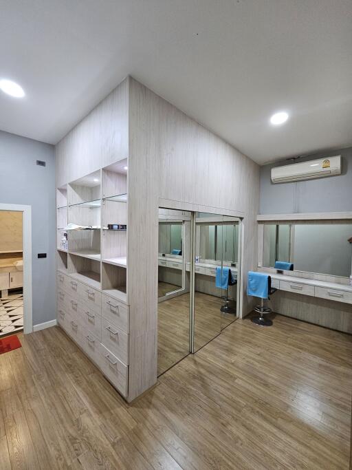 Spacious bedroom with built-in storage, vanity area, and air conditioning