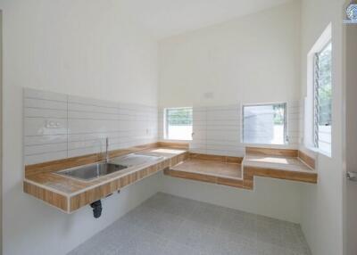 Minimalist kitchen with wooden countertops and white tiles