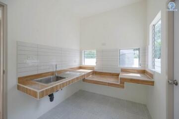 Minimalist kitchen with wooden countertops and white tiles