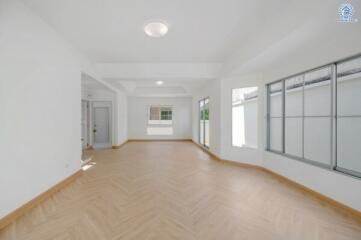 Spacious living room with large windows and wooden flooring