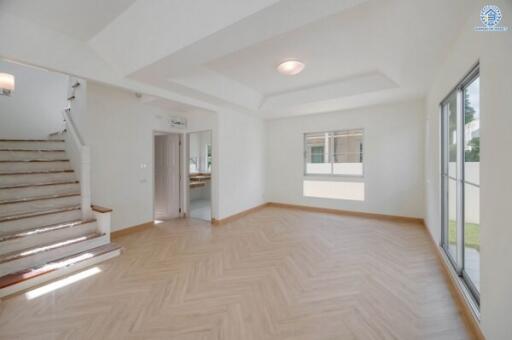 Spacious living room with large windows and staircase