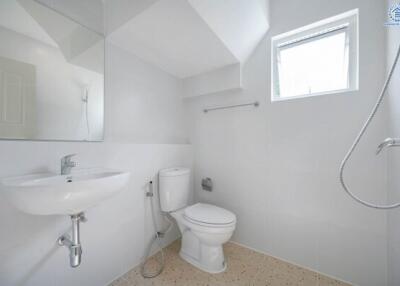 Bright bathroom with white fixtures and a small window