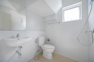 Bright bathroom with white fixtures and a small window