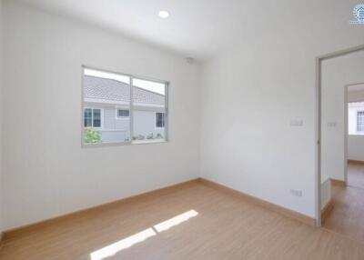 Bright unfurnished bedroom with window and wooden floor