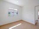 Bright unfurnished bedroom with window and wooden floor