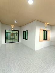 Spacious empty room with tiled floor and modern lighting